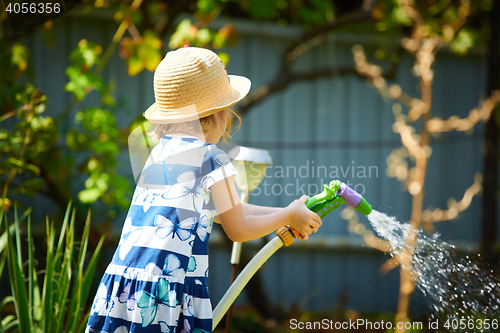 Image of Little happy girl watering garden