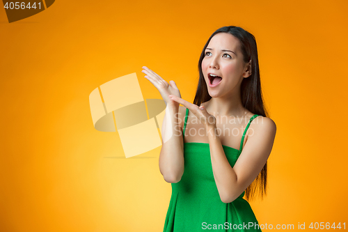 Image of The surprised Chinese girl on yellow background