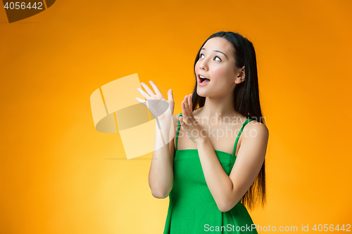 Image of The surprised Chinese girl on yellow background