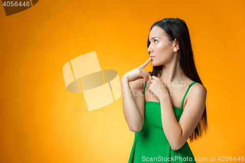 Image of The thinking Chinese girl on yellow background