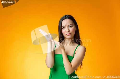 Image of The thinking Chinese girl on yellow background