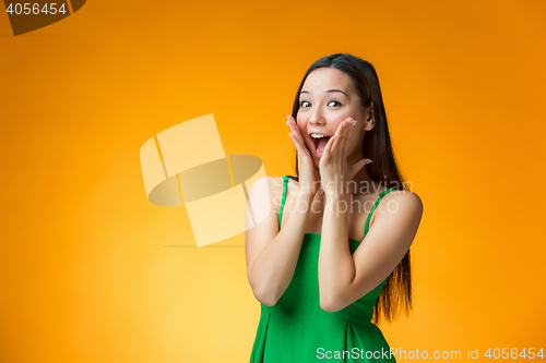 Image of The surprised Chinese girl on yellow background