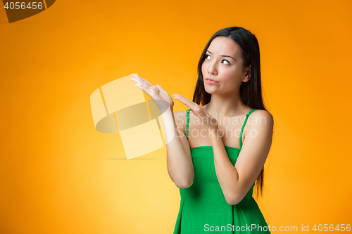 Image of The thinking Chinese girl on yellow background