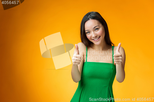 Image of The happy Chinese girl on yellow background