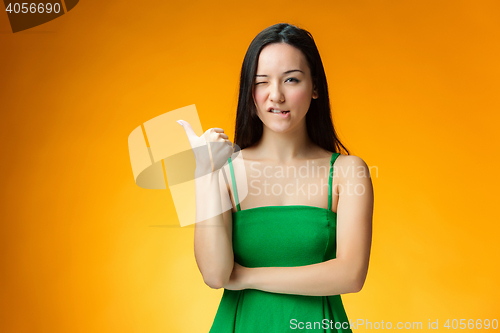 Image of The happy Chinese girl on yellow background