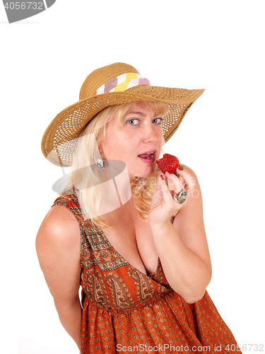 Image of Woman eating strawberry.
