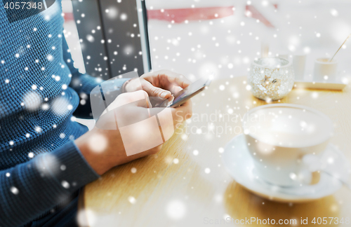 Image of close up of man with smartphones at cafe