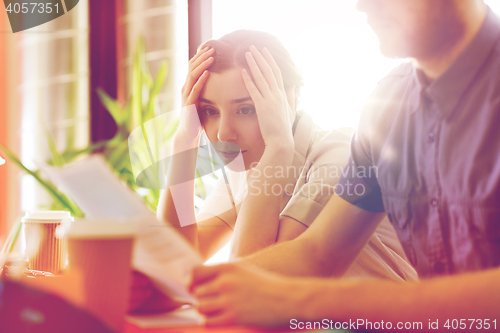 Image of creative team with reading paper in office