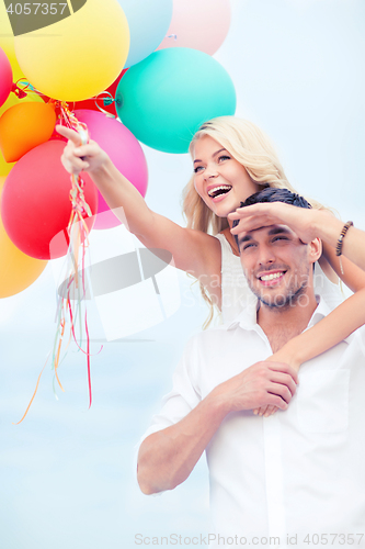 Image of couple with colorful balloons at seaside