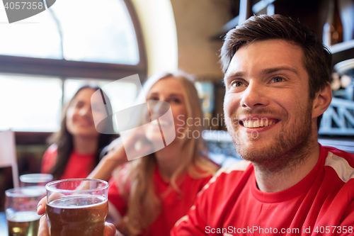 Image of fans or friends watching football at sport bar