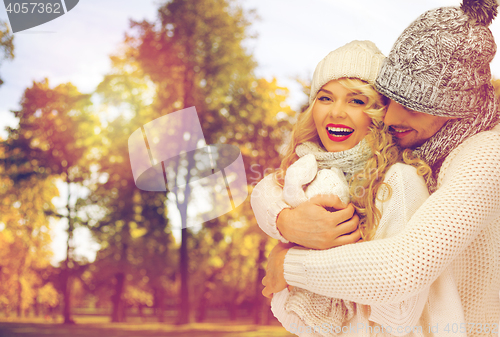 Image of happy couple in warm clothes over autumn