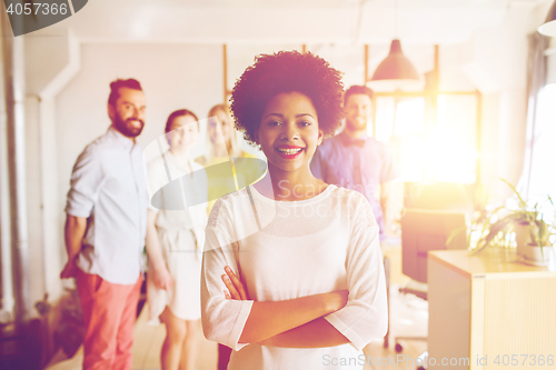 Image of happy young woman over creative team in office