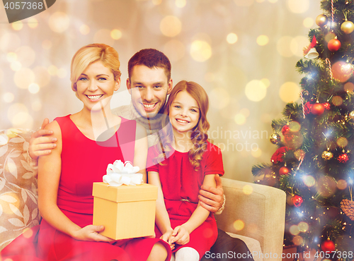 Image of smiling family holding gift box