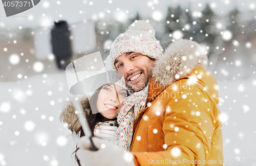 Image of happy couple taking selfie by smartphone in winter