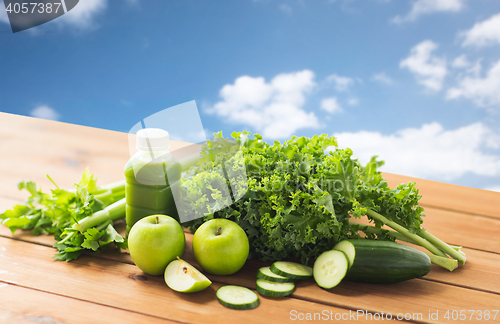 Image of close up of bottle with green juice and vegetables