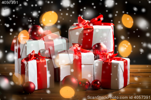 Image of gift boxes and red christmas balls on wooden floor