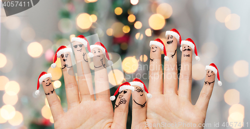 Image of close up of fingers with smiley in santa hats