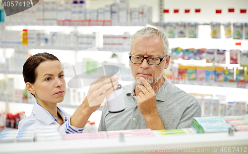 Image of pharmacist showing drug to senior man at pharmacy