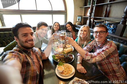 Image of happy friends taking selfie at bar or pub