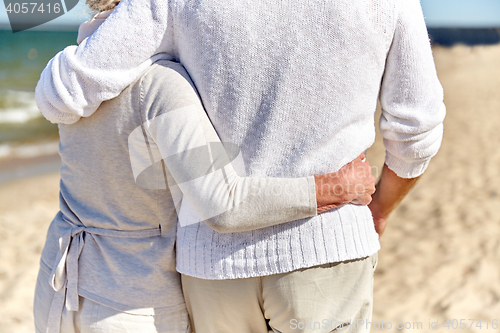 Image of close up of happy senior couple hugging on beach