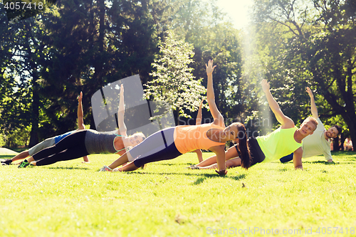 Image of group of happy friends exercising outdoors