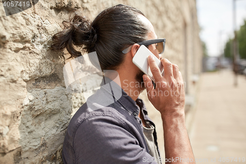 Image of close up of man calling on smartphone in city