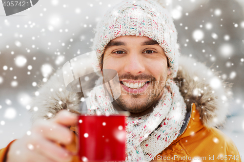 Image of happy man with tea cup outdoors in winter