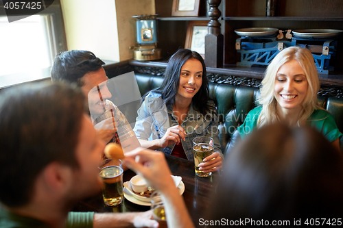 Image of friends dining and drinking beer at restaurant