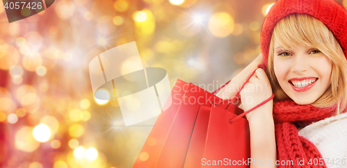 Image of happy woman in winter clothes with shopping bags