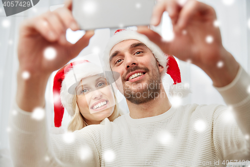 Image of couple taking selfie with smartphone at christmas