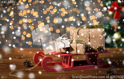 Image of close up of christmas gift boxes on wooden sleigh