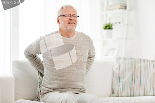 Image of unhappy senior man suffering from backache at home