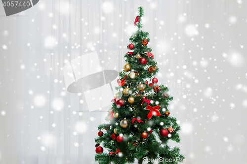 Image of christmas tree in living room over window curtain