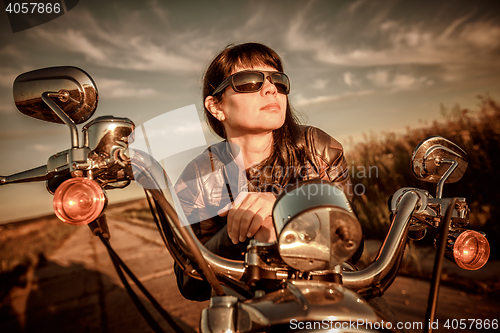 Image of Biker girl sitting on motorcycle