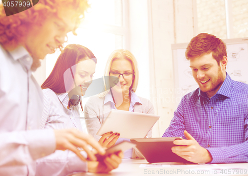 Image of smiling team with table pc and papers working