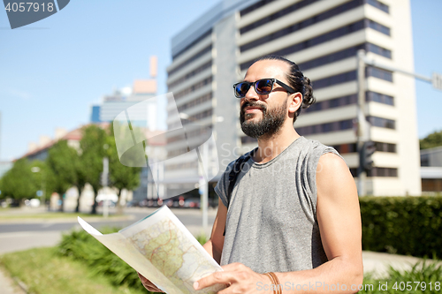 Image of man traveling with backpack and map in city