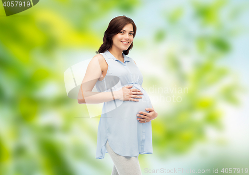 Image of happy pregnant woman touching her big belly