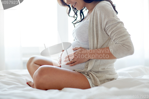 Image of close up of happy pregnant woman in bed at home