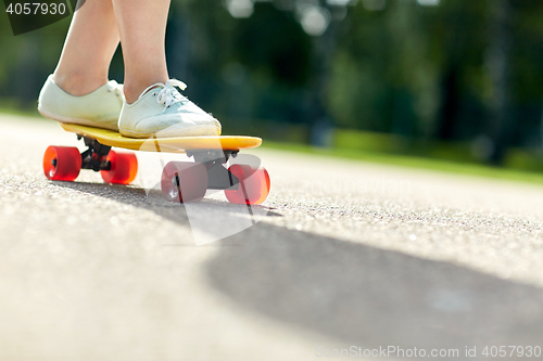 Image of close up of female feet riding short skateboard