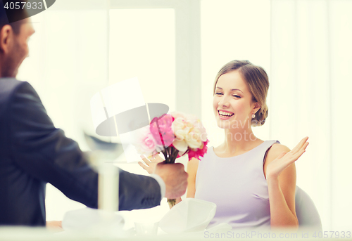 Image of amazed woman recieving bouquet of flowers