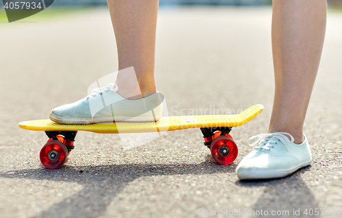 Image of close up of female feet riding short skateboard