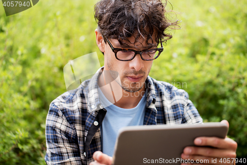 Image of man in glasses with tablet pc computer outdoors