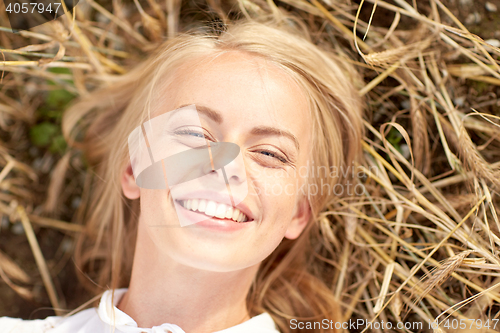 Image of happy young woman lying on cereal field