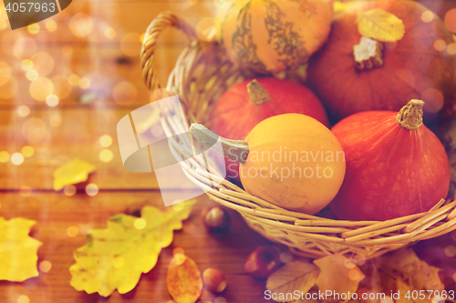 Image of close up of pumpkins in basket on wooden table