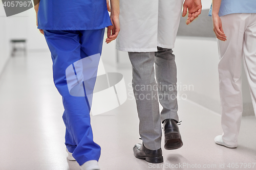 Image of group of medics or doctors walking along hospital