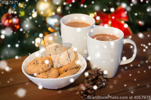 Image of oat cookies and hot chocolate over christmas tree