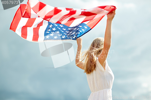 Image of happy young woman with american flag outdoors