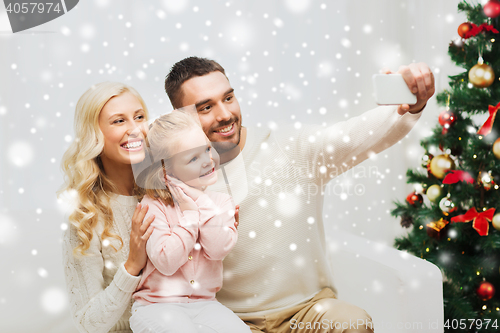 Image of family taking selfie with smartphone at christmas