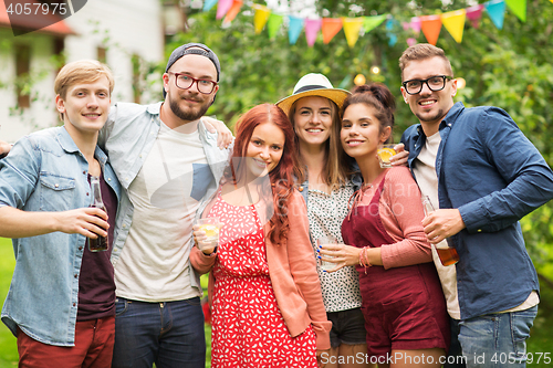 Image of happy friends with drinks at summer garden party