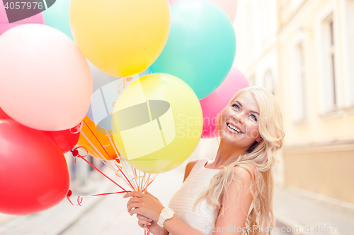 Image of smiling woman with colorful balloons